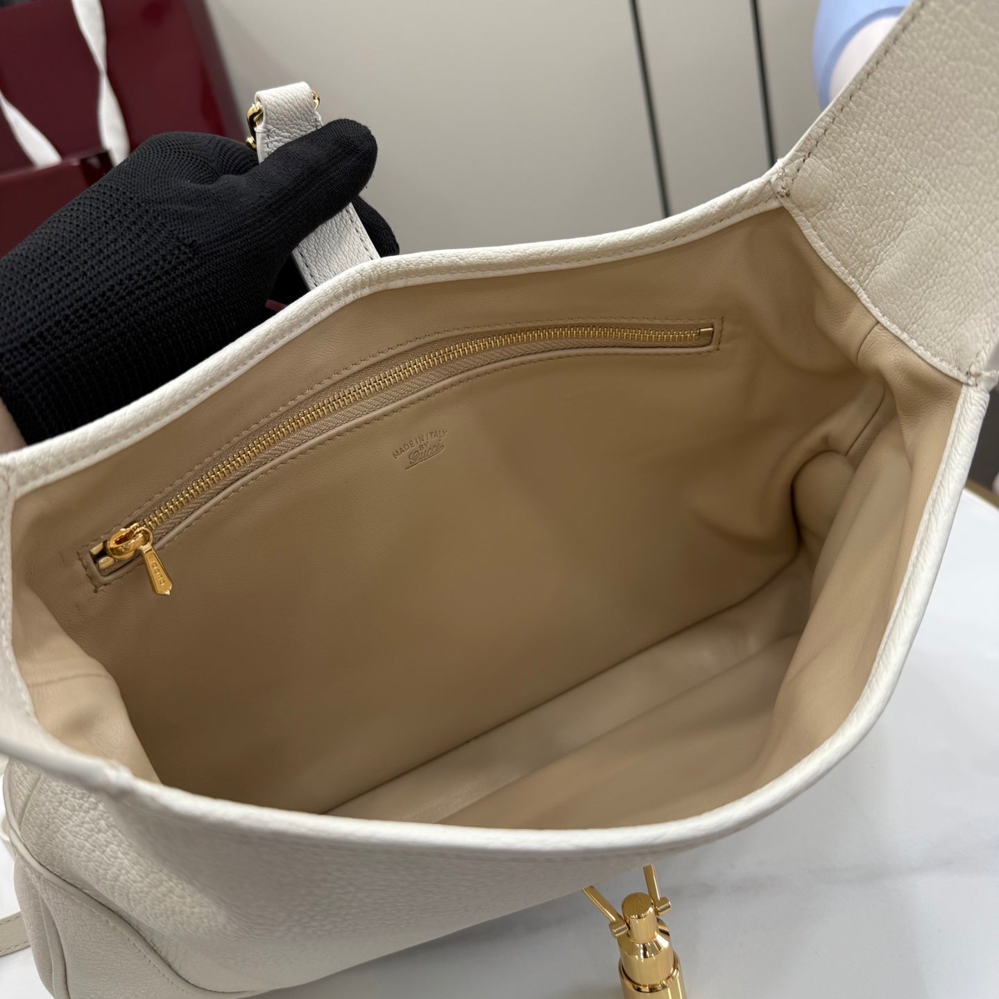 White leather tote interior with beige lining and gold zipper