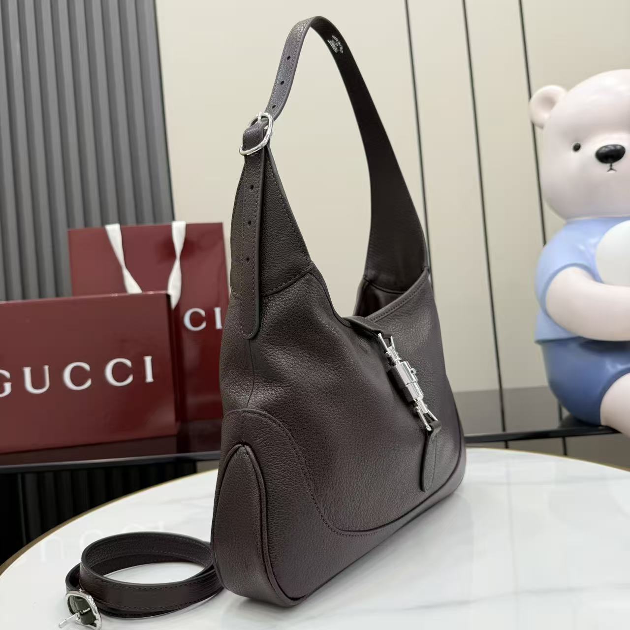 Dark brown leather hobo bag with detachable strap and front zipper detail