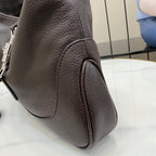 Pebbled leather handbag, dark side view with zipper pull and curved panel