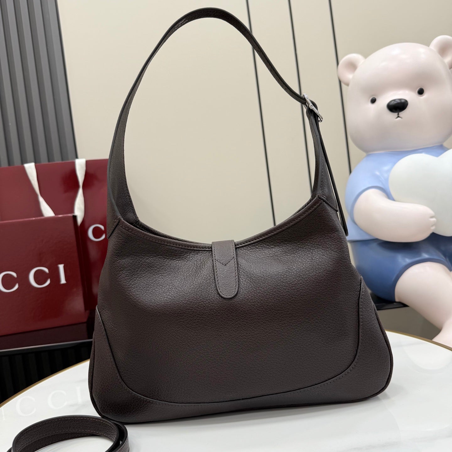 Dark brown leather hobo bag with curved top handles and central zipper closure