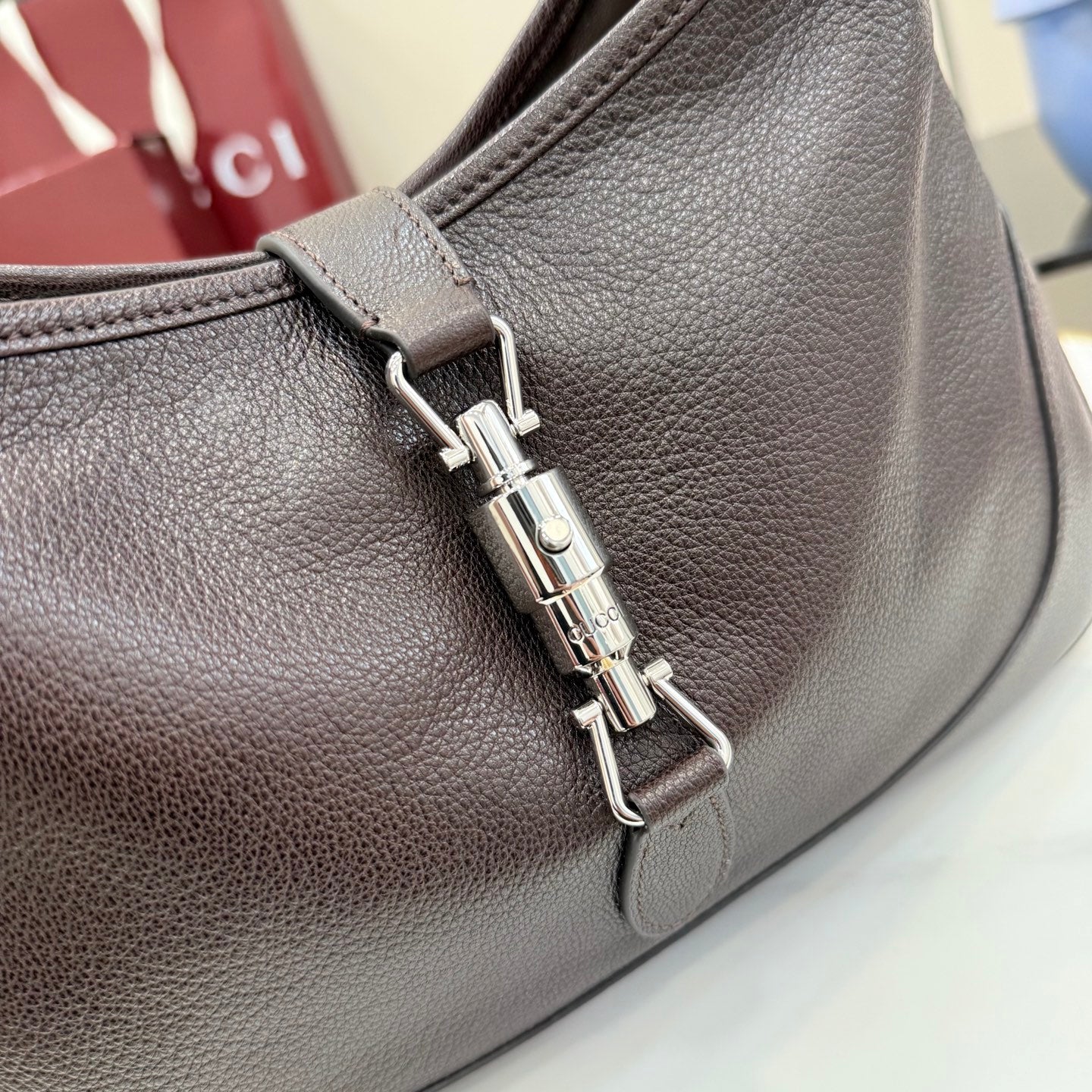 Dark brown leather bag with silver-toned zipper hardware and front seam