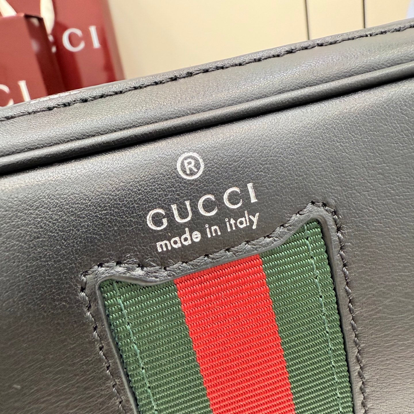 Gucci web stripe patch on black leather with Gucci made in Italy text