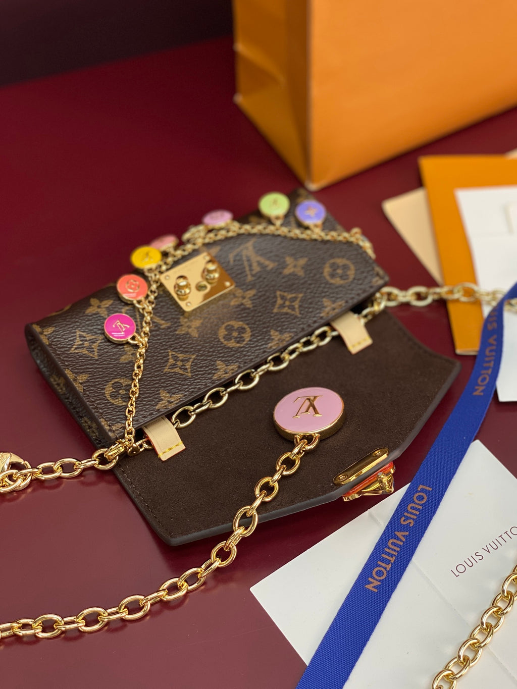 Louis Vuitton small bag with monogram canvas flap, gold chain strap, dangling charm details