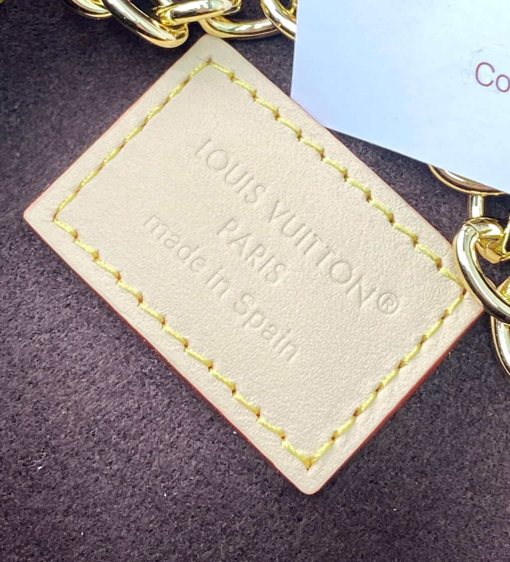 Louis Vuitton leather tag on gold chain, stamped text with yellow edge stitching