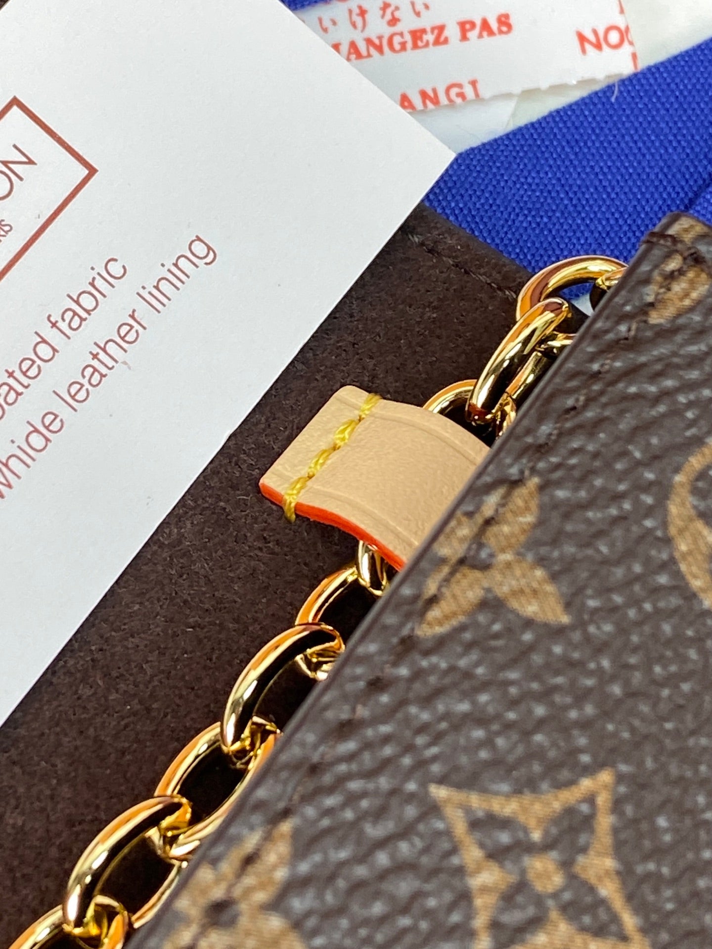 Louis Vuitton small bag side panel with gold chain links and leather strap
