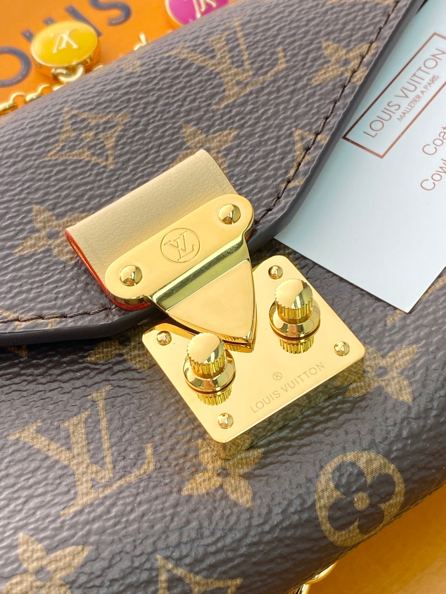 Louis Vuitton small bag detail: monogram canvas flap with gold clasp and snap hardware