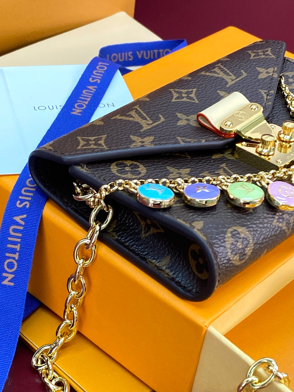 Louis Vuitton small bag with monogram canvas flap, gold chain strap, multicolor charm discs
