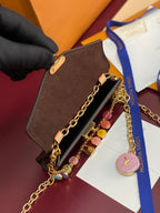 Louis Vuitton small bag with monogram canvas, gold chain strap, charm tag and hardware