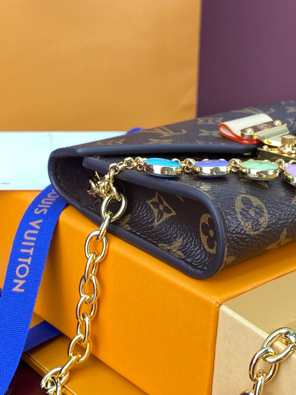 Louis Vuitton small bag with monogram canvas and rolled handle, gold chain charm attachment