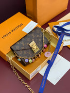 Louis Vuitton small bag with monogram canvas flap, gold chain strap, colorful charm accents