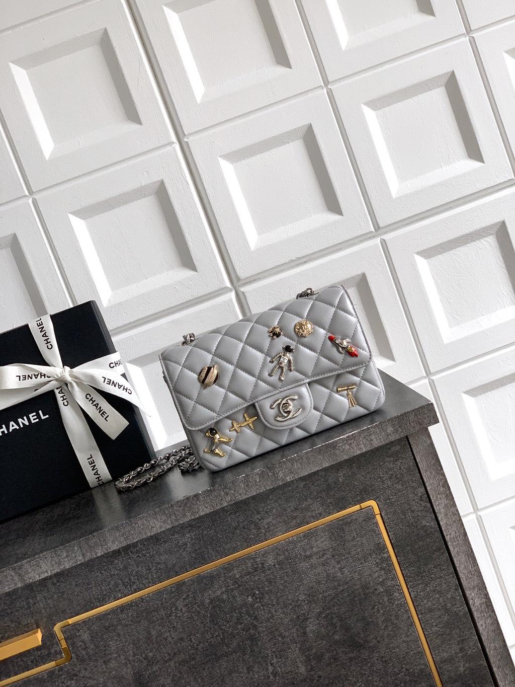 Quilted leather flap shoulder bag with chain strap and gold-tone charms, gray