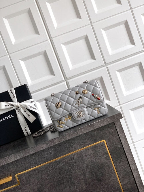 Quilted leather flap shoulder bag with chain strap and gold-tone charms, gray