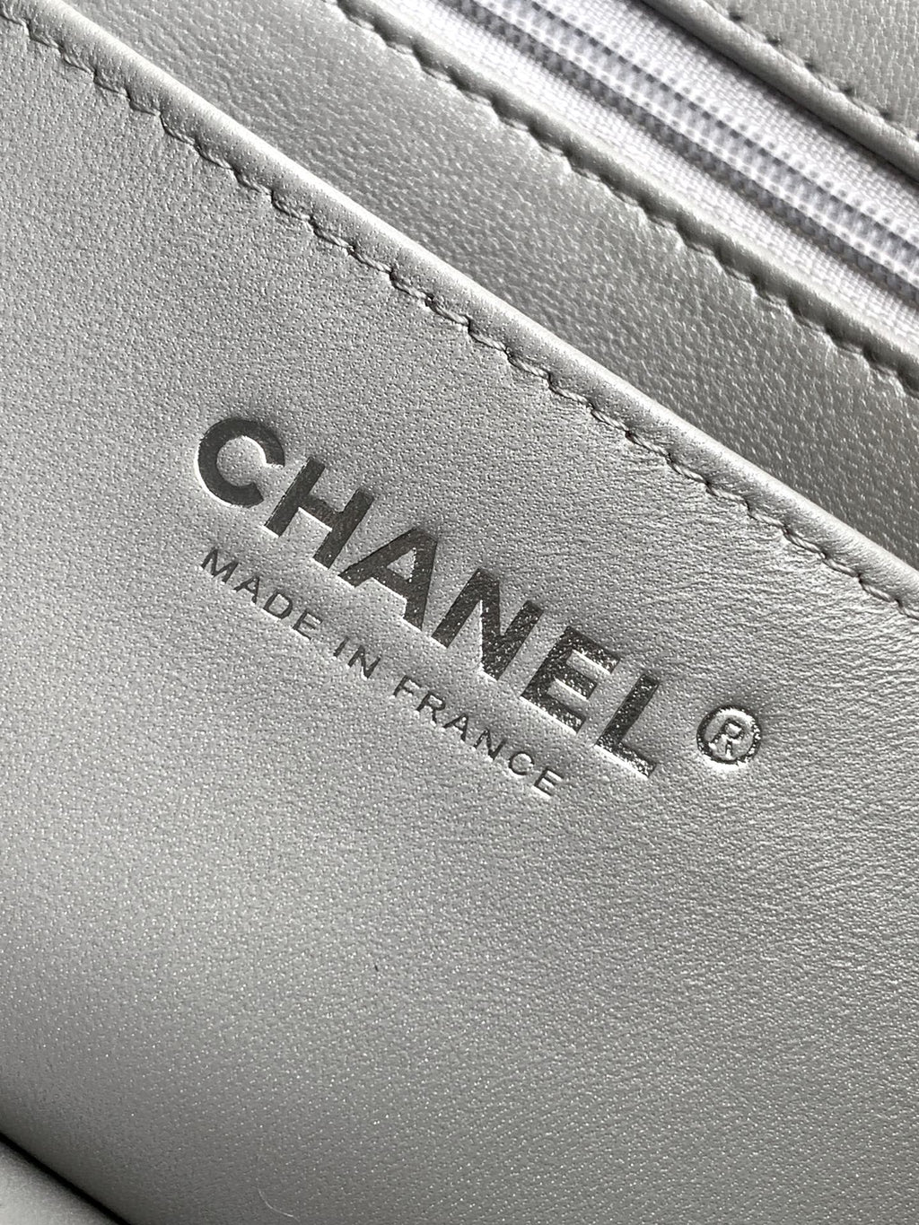 Close-up of Chanel label inside quilted leather bag, gray text "Made in France"