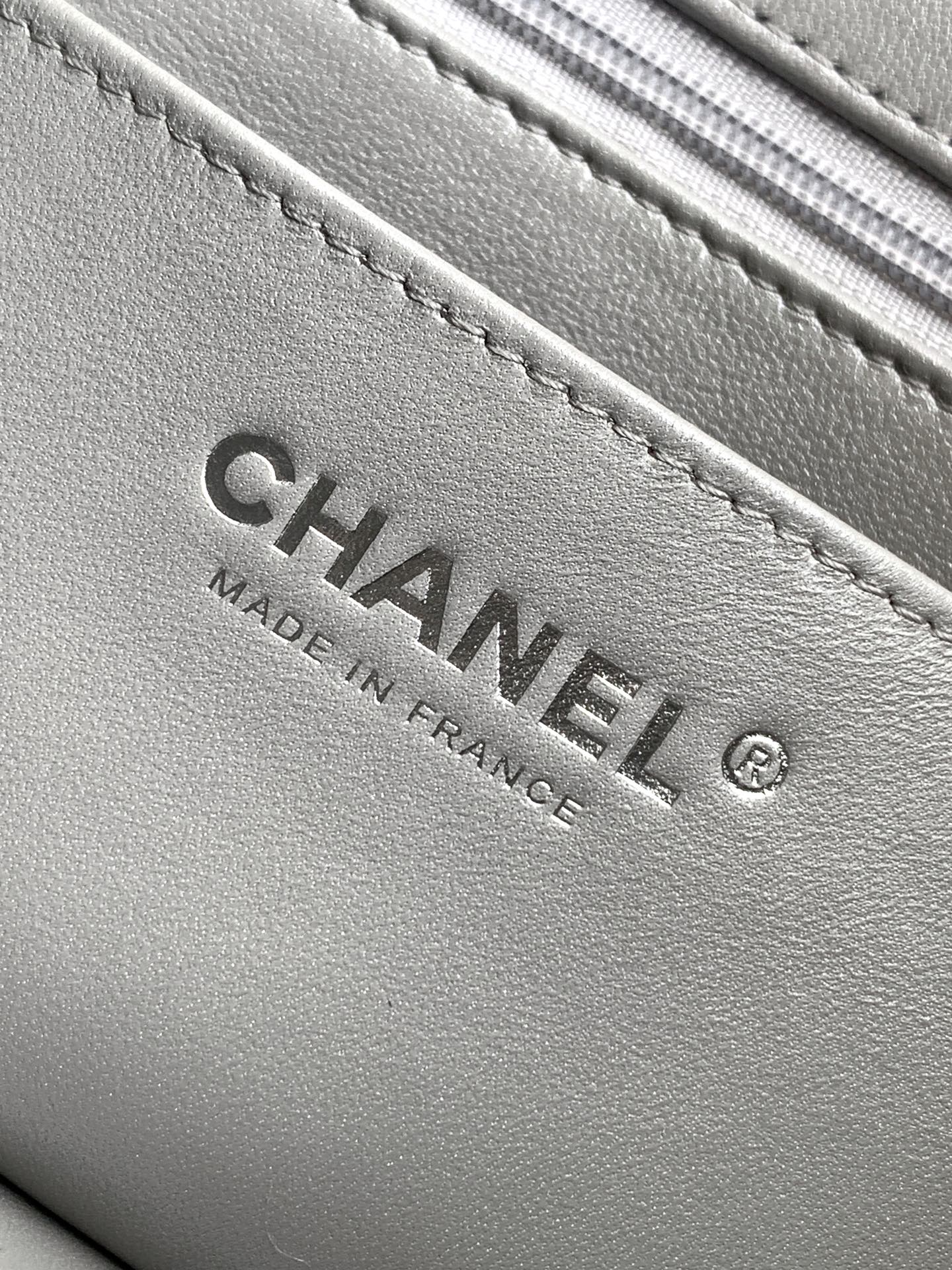 Close-up of Chanel label inside quilted leather bag, gray text "Made in France"