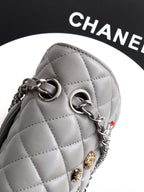 Chanel quilted leather bag close-up with round ring hardware and light gray finish