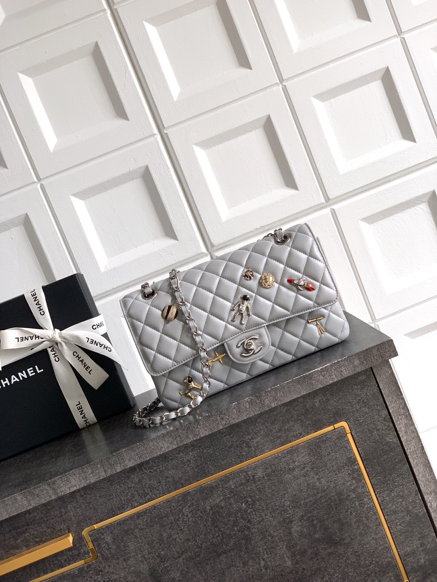 Chanel quilted shoulder bag with silver chain and metal turn-lock clasp, light gray