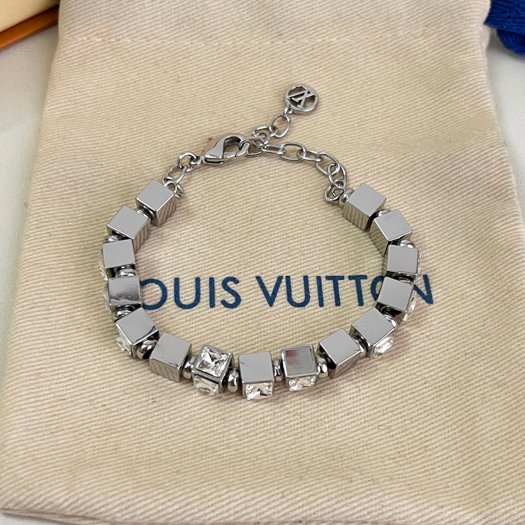 Close-up: silver rhinestone bracelet with square links and small logo charm on top