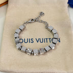 Close-up: silver rhinestone bracelet with square links and small logo charm on top