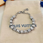Close-up: silver rhinestone charm bracelet with square links and logo detail