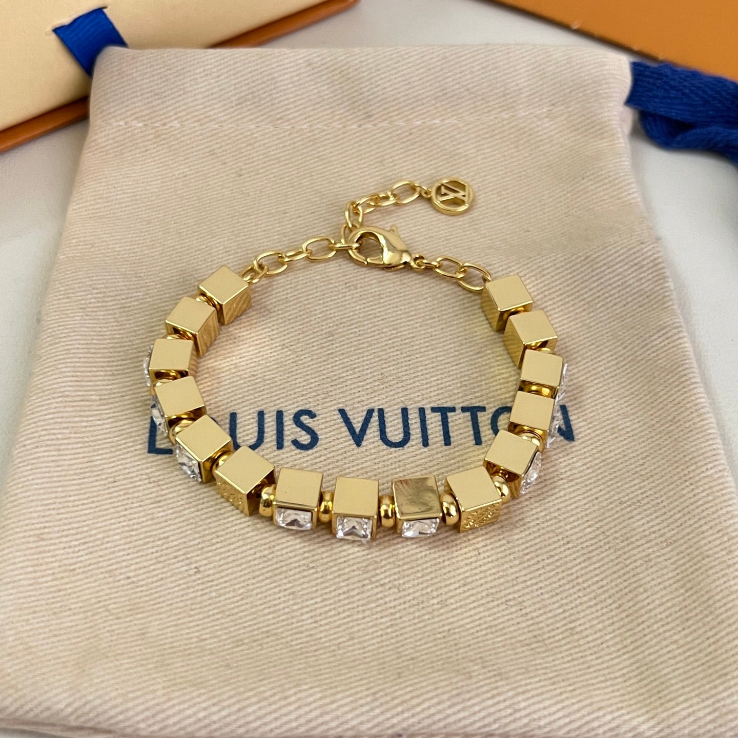 Gold-tone bracelet with square clear stones and hinged chain clasp