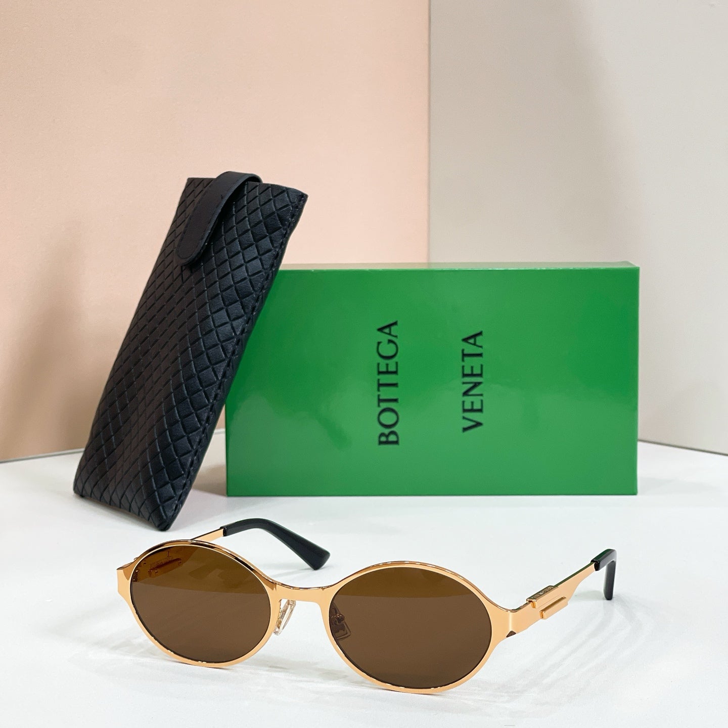Gold-tone round sunglasses with brown-tinted lenses and black quilted case