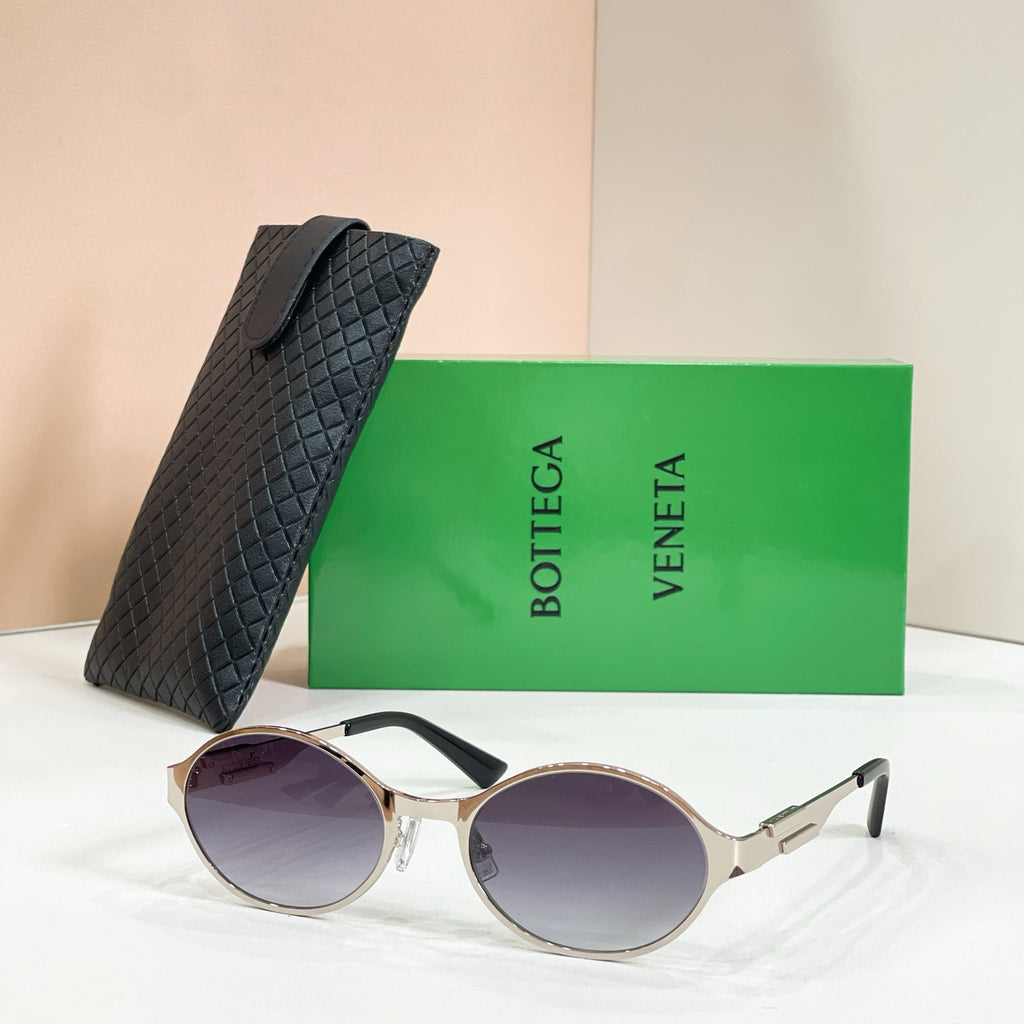Gold-tone round sunglasses with purple-tinted lenses and black quilted case