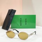 Gold-tone round sunglasses with amber-tinted lenses and black quilted case