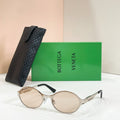 Gold-tone round sunglasses with light-tinted lenses and black quilted case