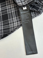 Inside label on black-and-white plaid hooded shirt showing BALENCIAGA product details