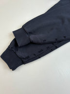 Bottom hem detail of dark navy long-sleeve hooded shirt with stitched facing