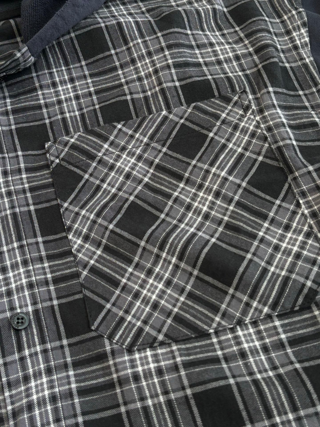 Detail view of black-and-white plaid long-sleeve hooded shirt fabric and buttons