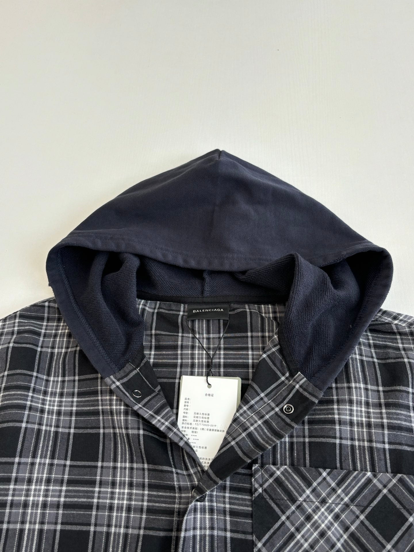 Hooded neckline of dark navy long-sleeve plaid shirt with inner hood lining