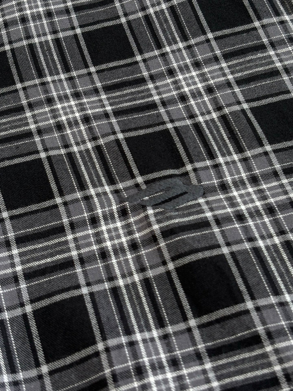 Black and white plaid fabric close-up with intersecting grid lines
