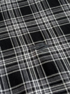 Black and white plaid fabric close-up with intersecting grid lines
