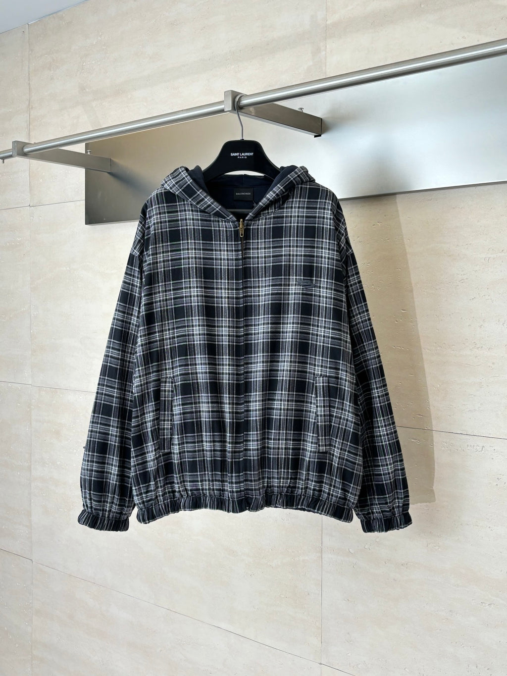 Zip-up hooded jacket in black and white plaid with front zipper and elastic cuffs