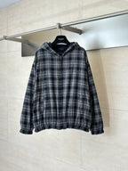 Zip-up hooded jacket in black and white plaid with front zipper and elastic cuffs