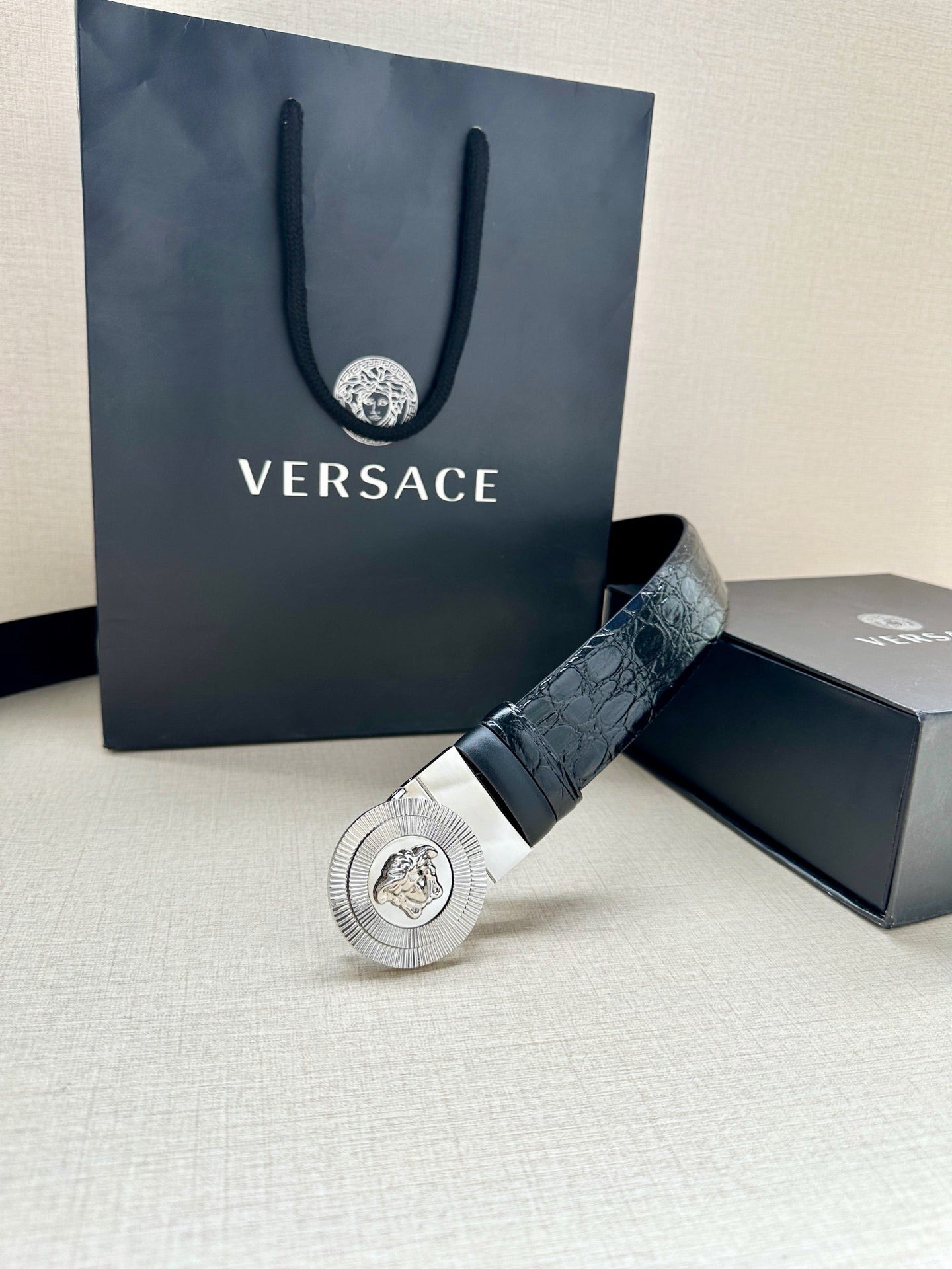 Dark blue embossed leather belt with silver Medusa buckle and gift packaging