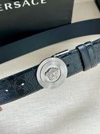 Dark blue embossed leather belt with round silver Medusa buckle, close-up