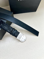 Dark blue leather belt with embossed pattern and round silver buckle, side view