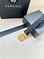 Dark leather belt with gold Medusa round buckle and visible adjustment holes