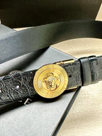 Dark embossed leather belt with gold Medusa round buckle and slim strap