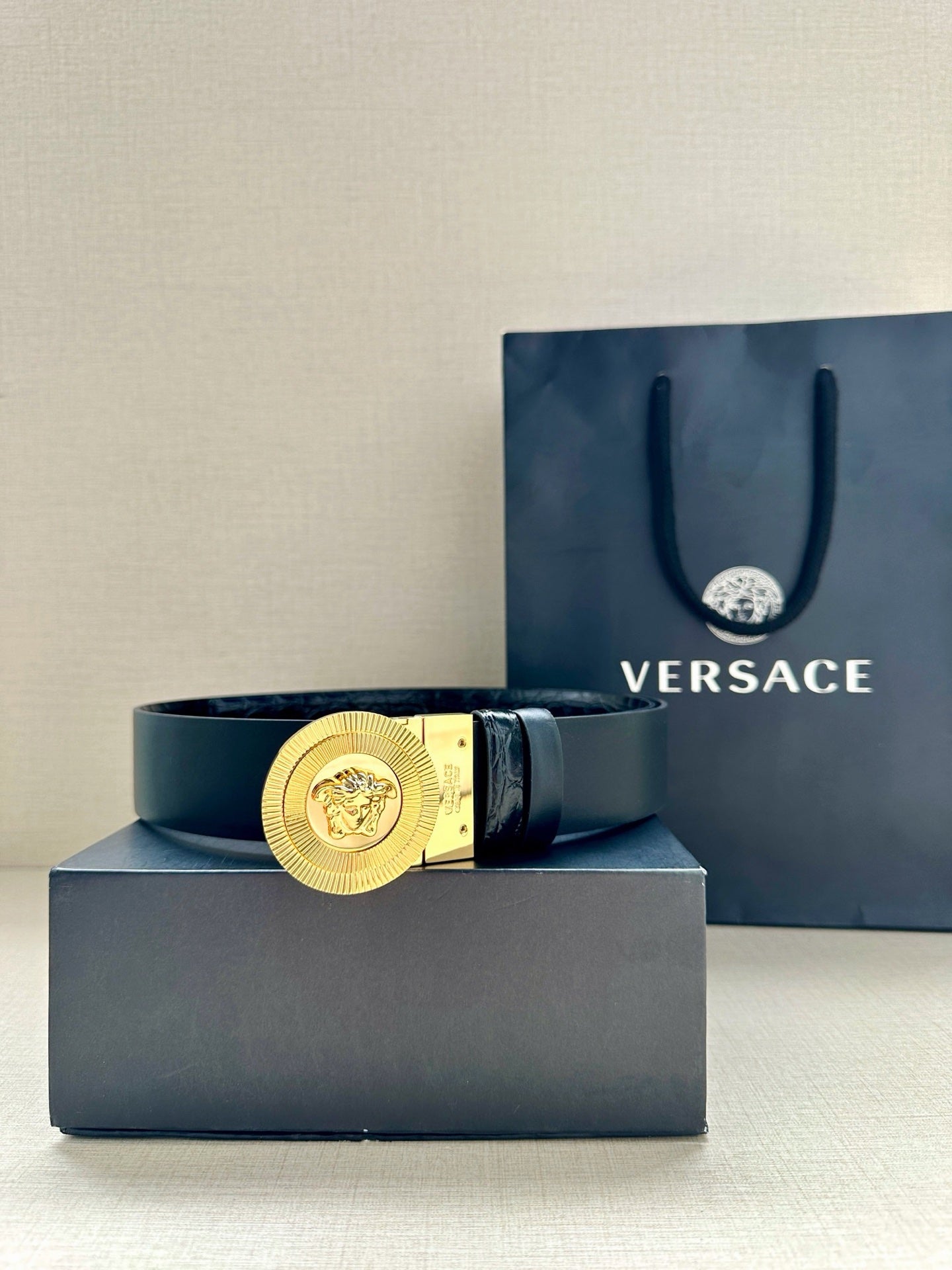 Versace dark leather belt with gold Medusa round buckle on the center strap