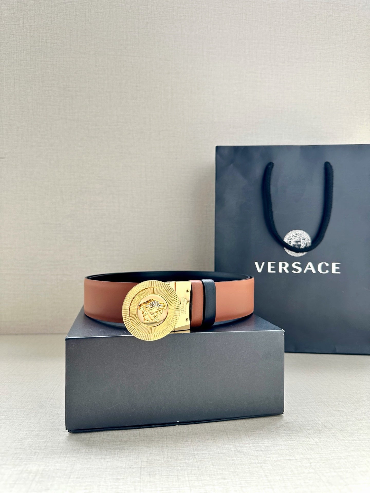 Versace belt with gold medallion buckle, dark navy strap and orange underside