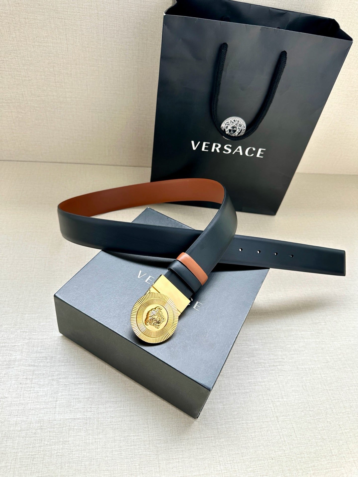 Versace belt in gift box: gold medallion buckle on dark navy leather with orange edge