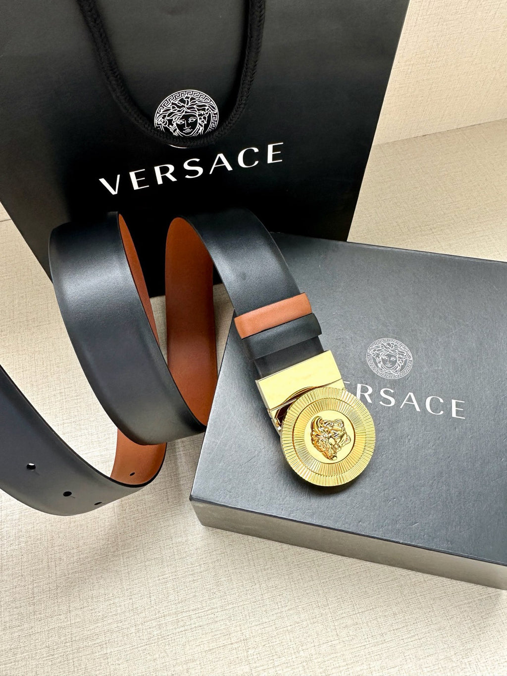 Versace belt with gold medallion buckle, dark navy strap and orange inner band