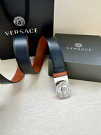 Dark navy leather belt with silver Medusa buckle, tan accents, and punched sizing holes