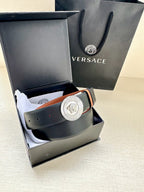 Leather belt in dark navy with round silver Medusa buckle, styled with tan lining