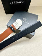 Navy leather belt with silver Medusa buckle, tan tabs, and multiple punched holes