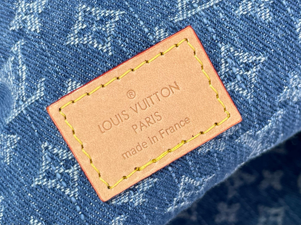 Louis Vuitton bag leather label on blue denim, tan trim and yellow stitching