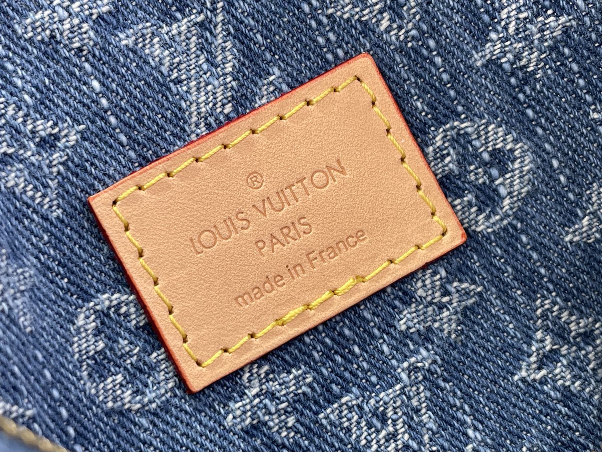 Louis Vuitton bag leather brand tag on blue denim with yellow stitched border